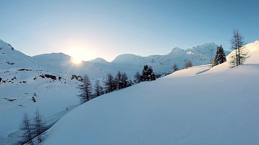 航拍冬日阳光下白雪覆盖的山峰视频的预览图