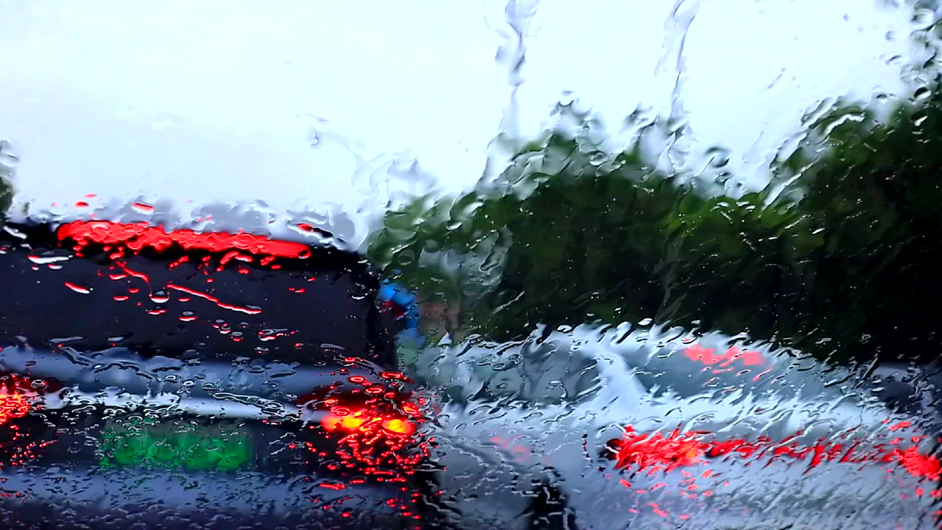 白天雨中前风挡雨幕对焦虚化车尾灯高清视频的预览图