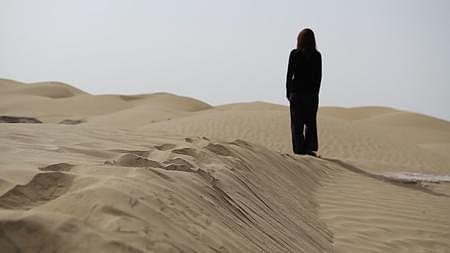 新疆沙漠无人区女生背影走路慢动作行走在沙丘日景1080P实拍视频视频的预览图