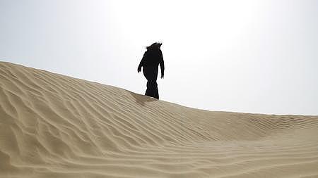 新疆无人区沙漠沙丘青年女性中午独自行走实拍视频视频的预览图