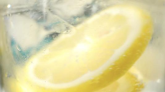 黄色的柠檬水加冰块特写镜头慢动作视频的预览图