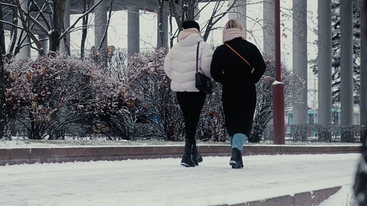 欧洲冬天下雪的傍晚街道上行走的女孩视频的预览图