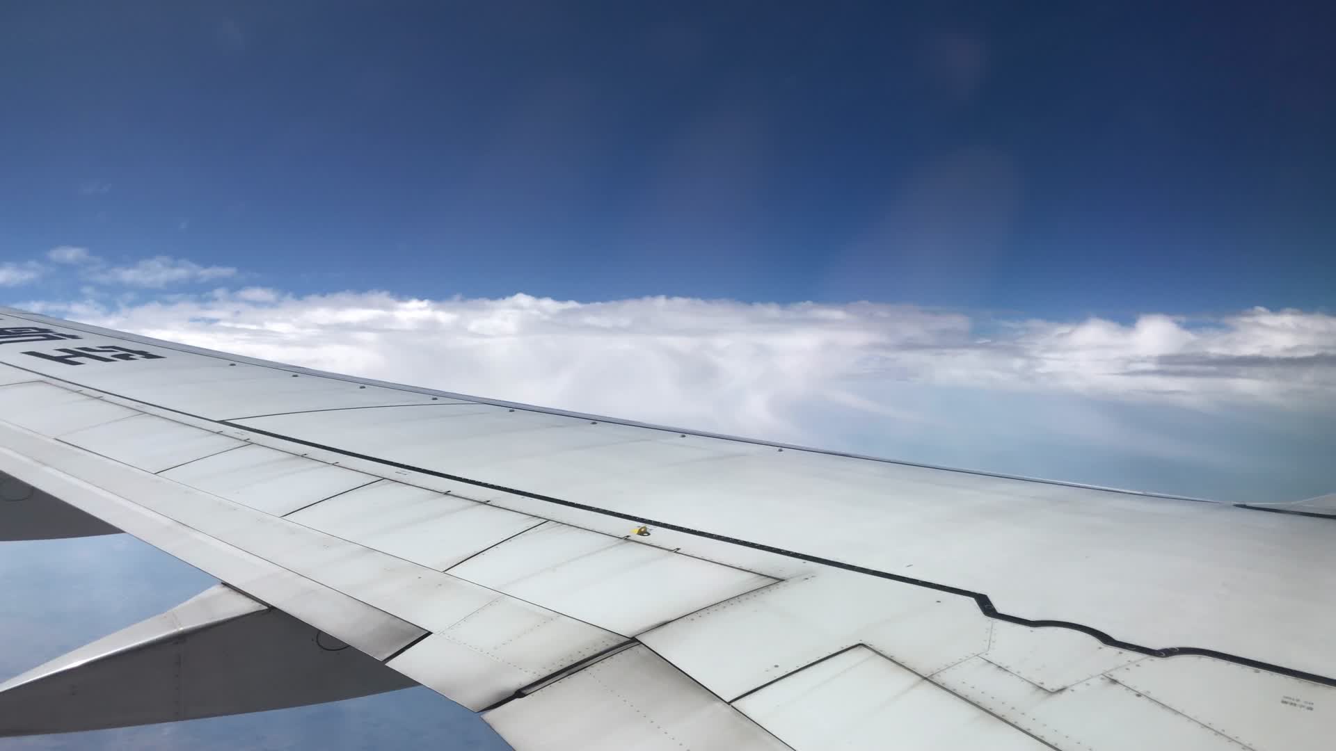 乘客视角拍摄飞机窗外的蓝天白云视频的预览图