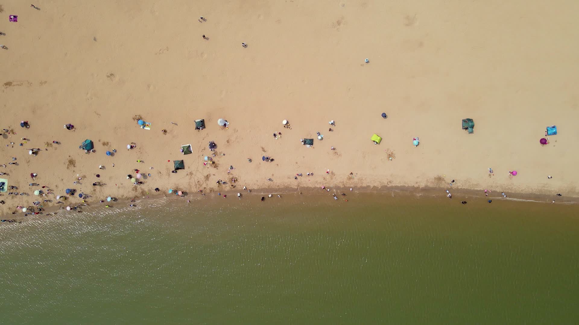 航拍夏日沙滩休闲人群视频的预览图