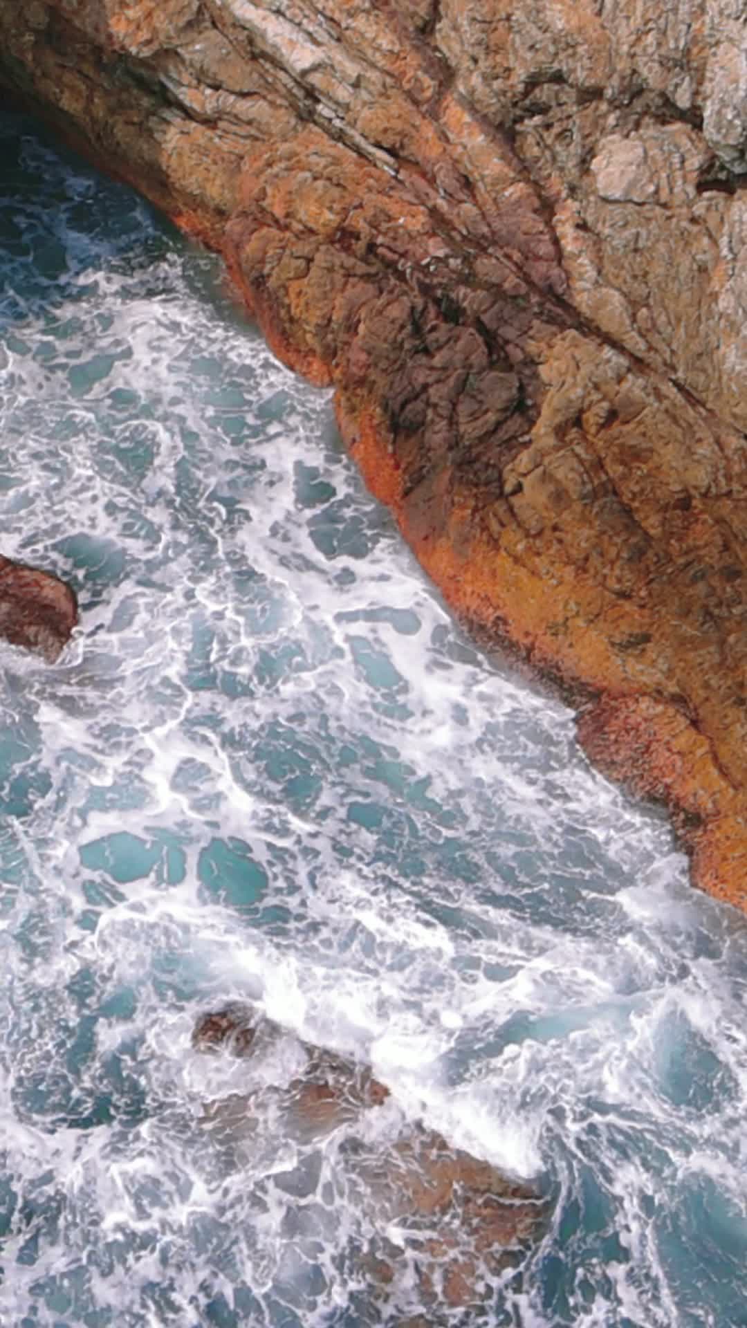 航拍海浪拍打礁石竖屏视频视频的预览图