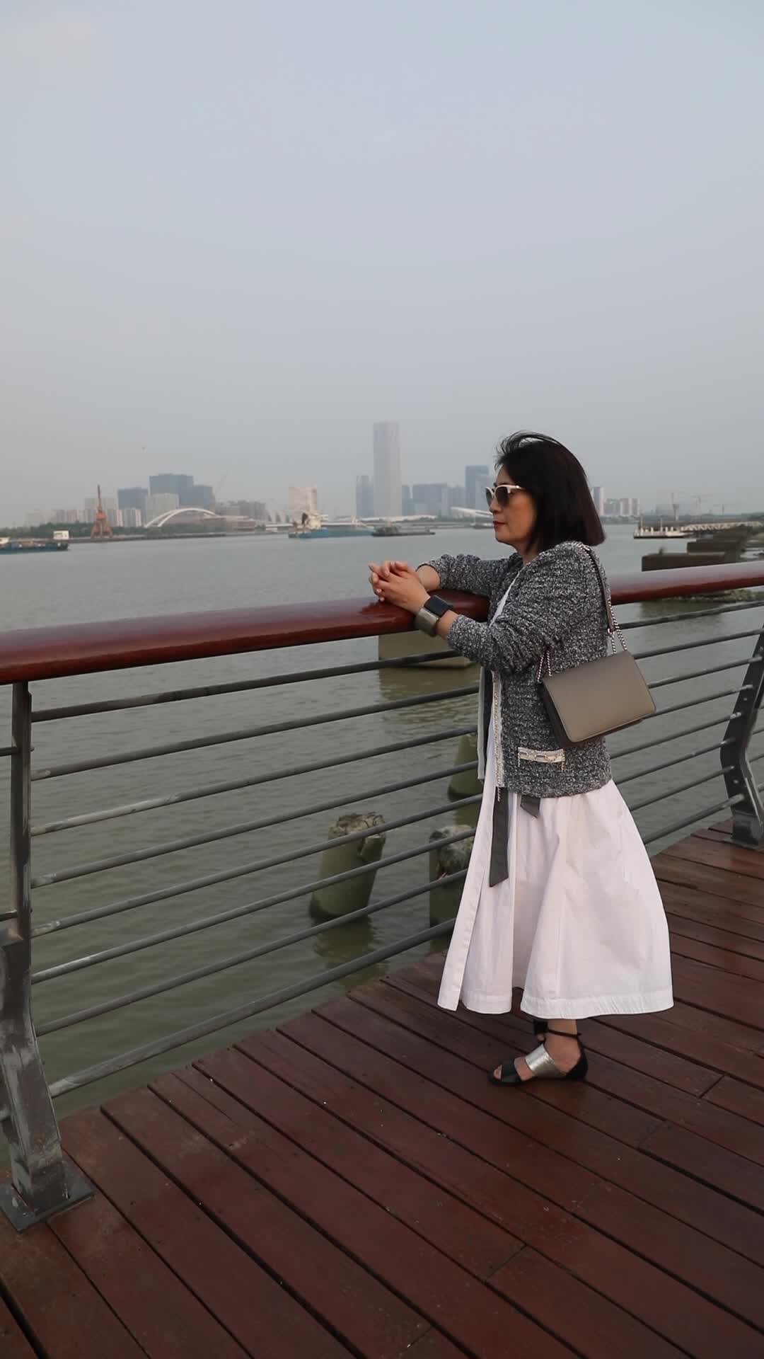 站在城市江边看都市风景思考的女人背影视频的预览图