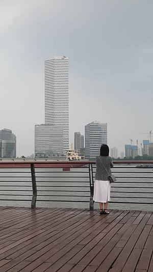 在城市江边看都市风景思考的女人背影视频的预览图