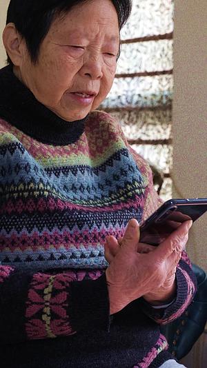 老年女人在家使用手机视频的预览图