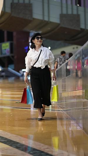 拿着购物袋走在购物中心的时尚女人视频的预览图