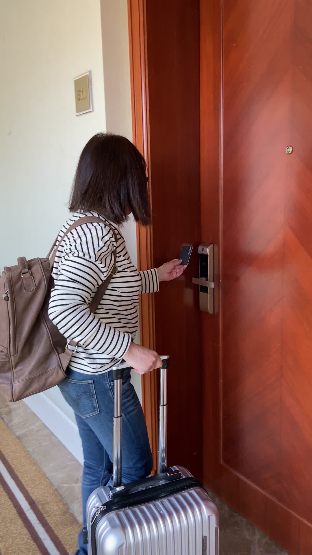 一个女人用门卡打开宾馆客房的房间门视频的预览图