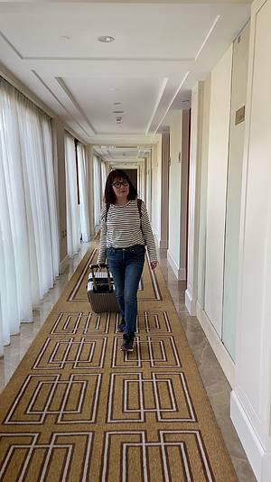 4K一个女人拉着行李箱走在酒店走廊视频视频的预览图