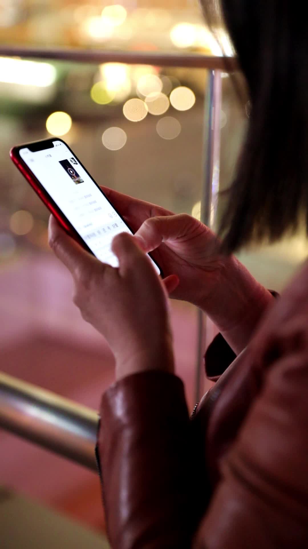 在户外夜晚使用手机的女人特写视频的预览图