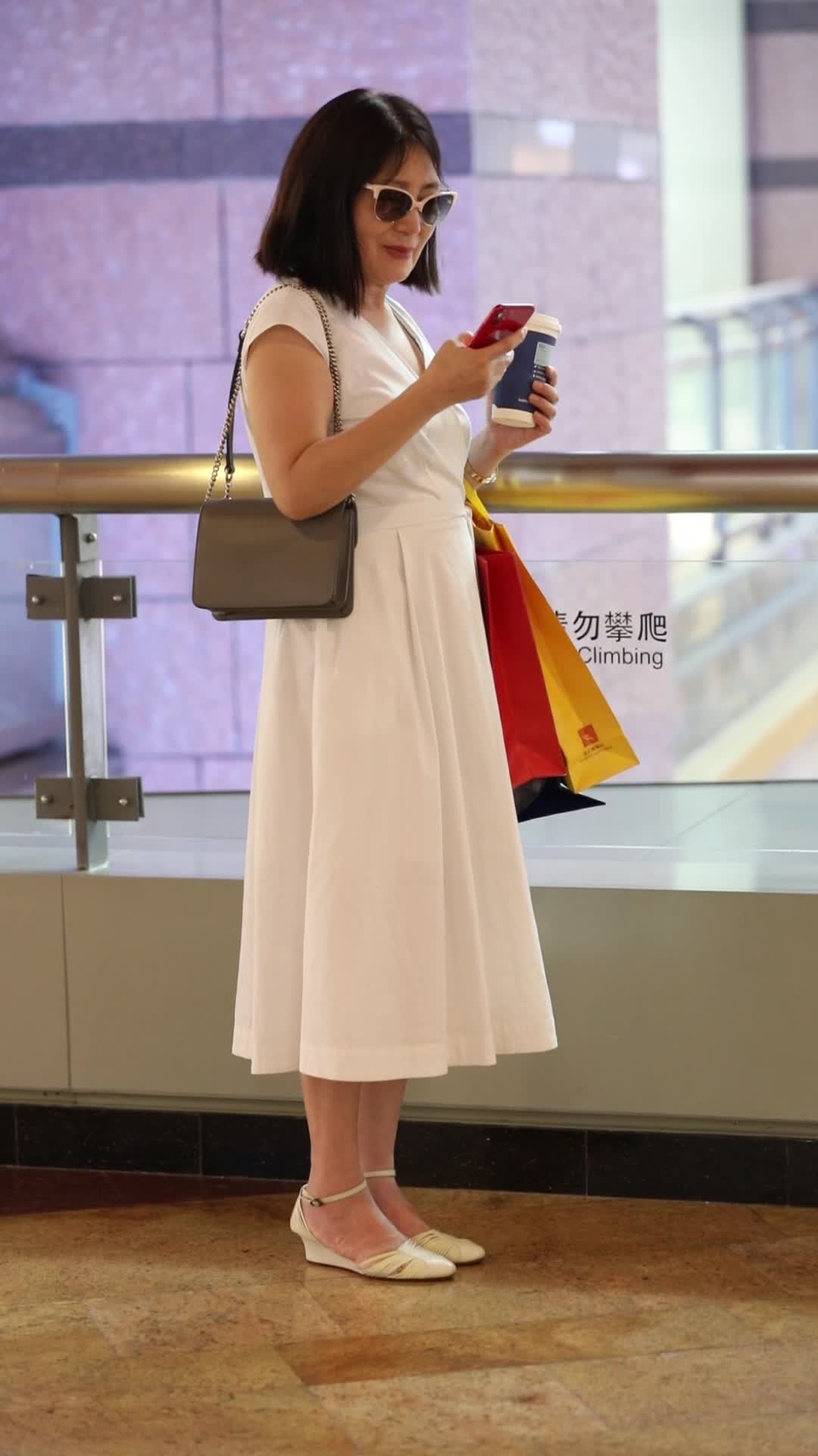 一个女人在购物中心内使用手机视频的预览图