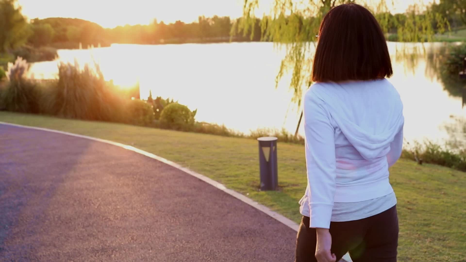 在户外公园散步健身的女人背影视频的预览图