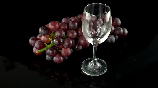 棚拍黑背景新鲜葡萄和葡萄酒视频的预览图