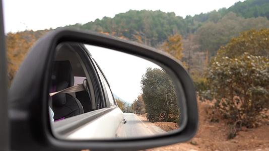 秋天行驶在公路上的汽车倒车镜视角视频的预览图