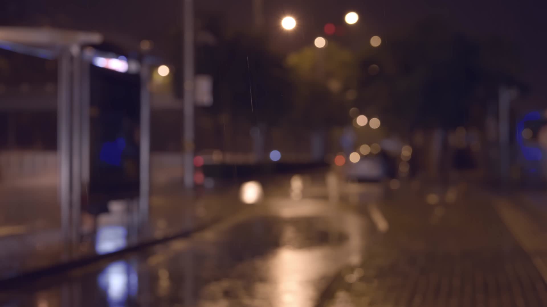 夜晚虚影公交站台附近的大雨视频的预览图