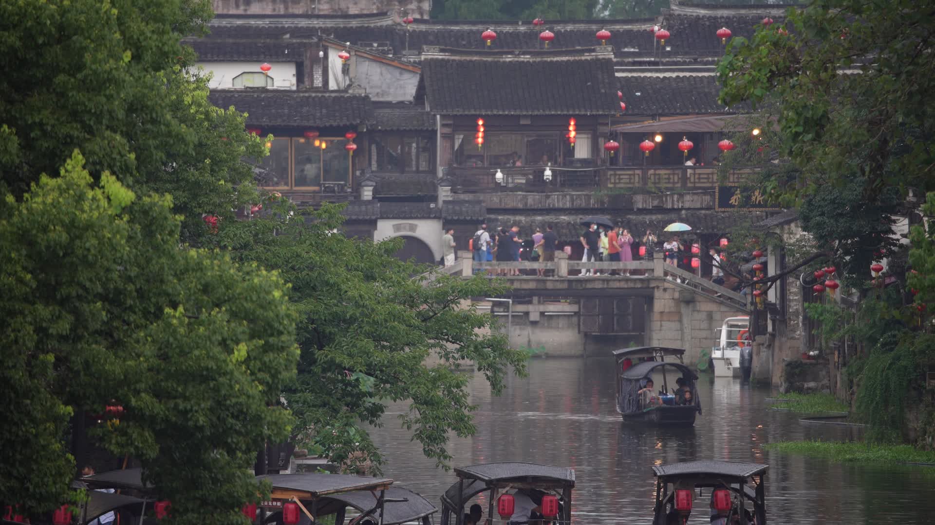 浙江西塘古镇游客乘坐乌篷船在古桥上游玩实拍视频的预览图