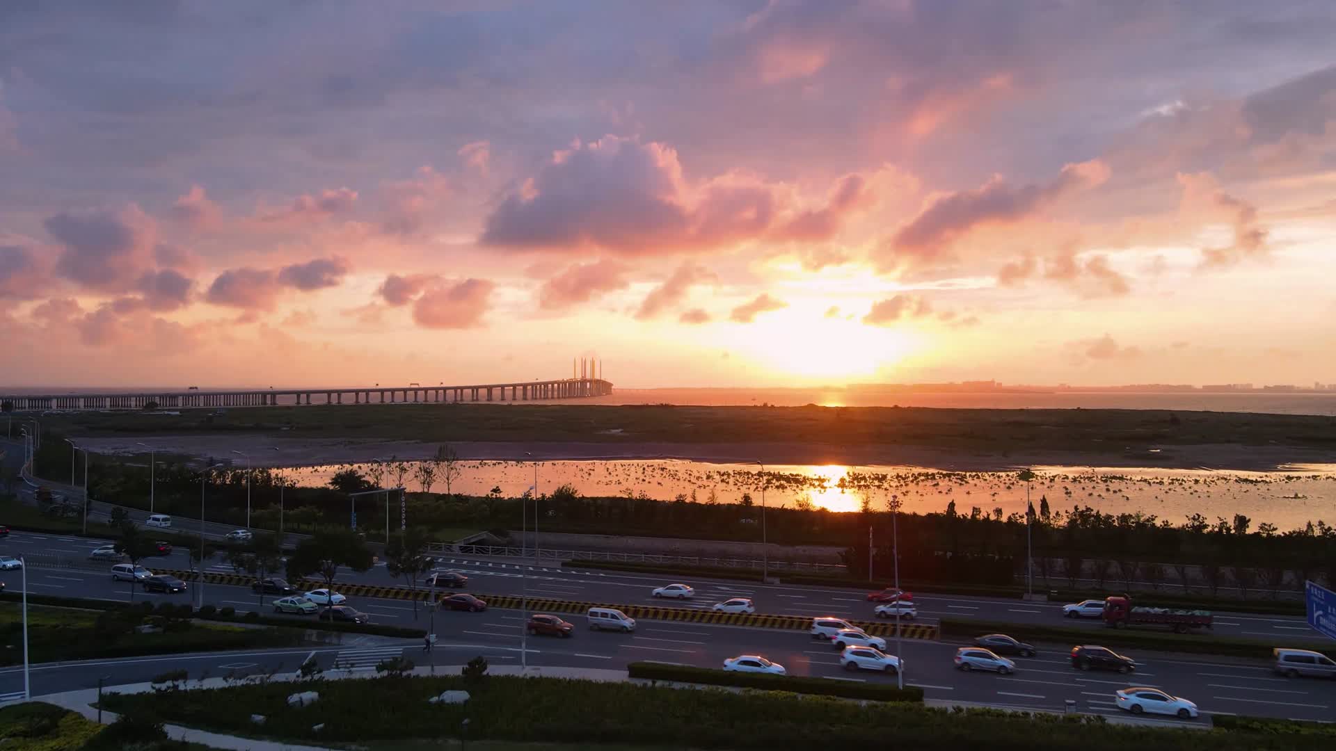 4K航拍青岛胶州湾大桥的火焰夕阳城市风貌视频的预览图