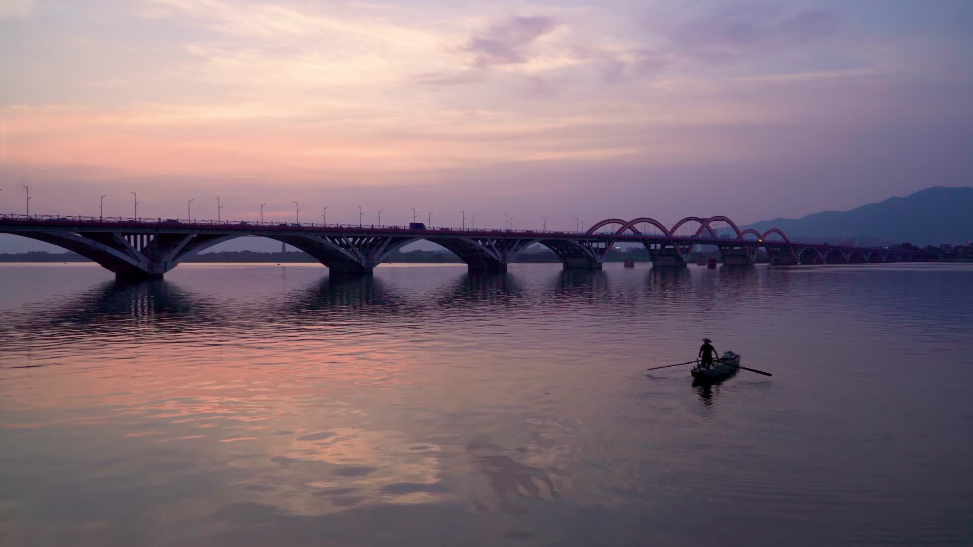 夕阳天空下的城市大桥和小船视频的预览图