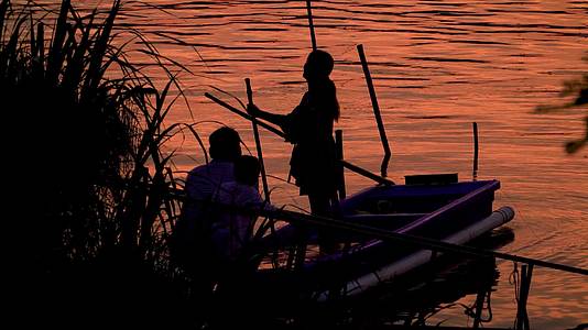 在夕阳下水边划船拍照的一家人视频的预览图
