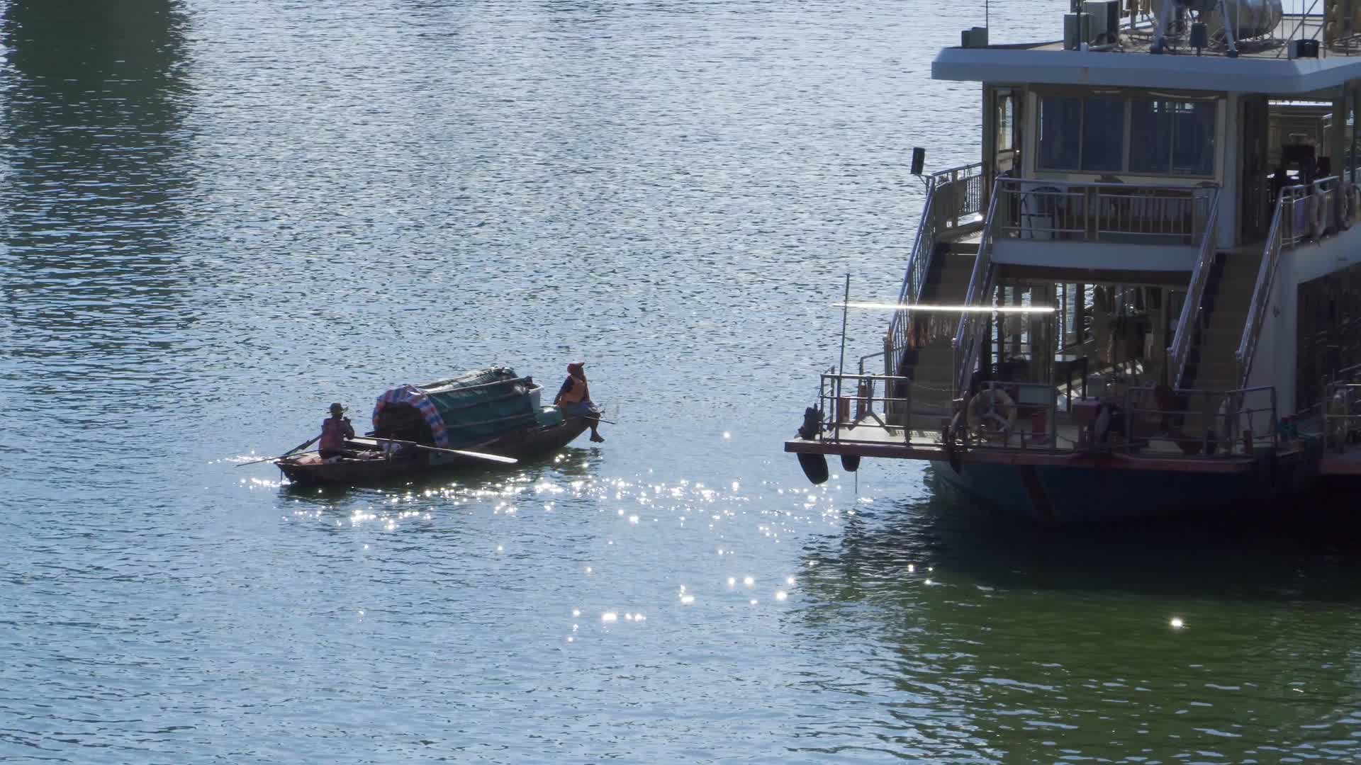 划着渔船的人经过一艘轮船视频的预览图