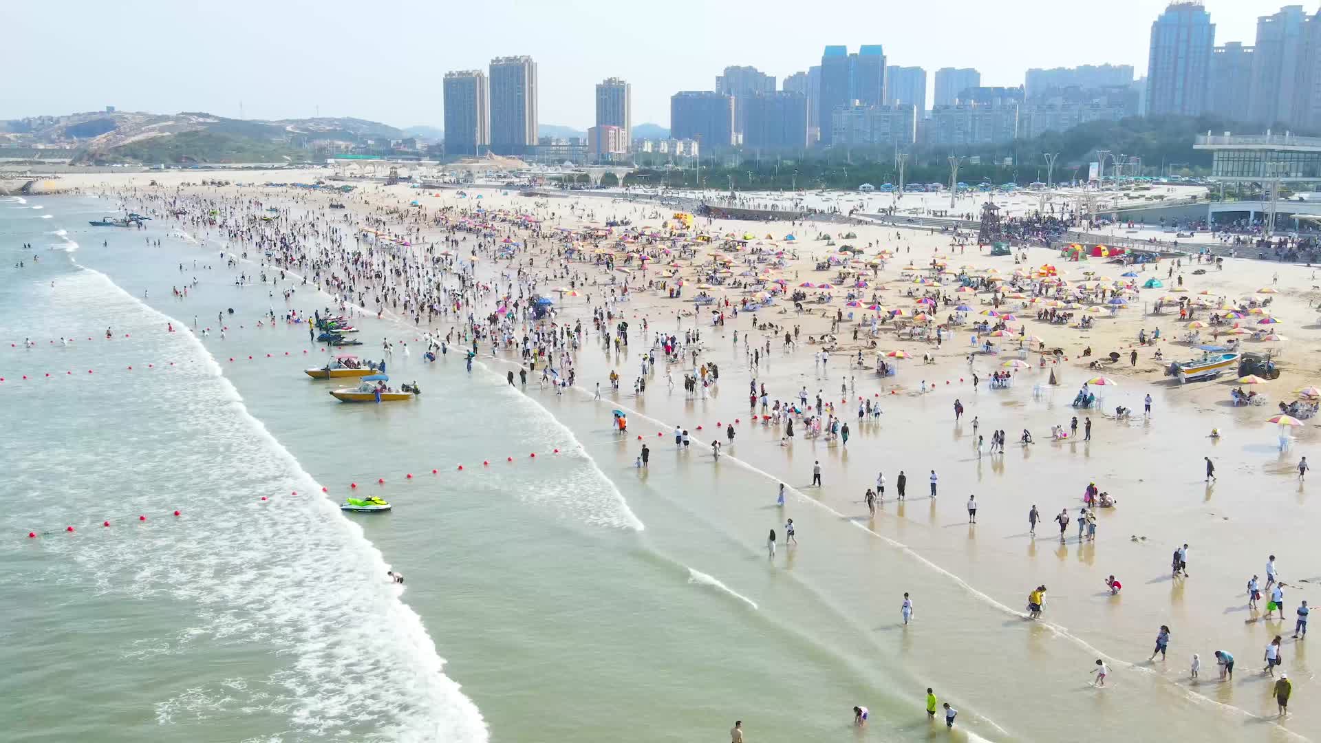 4K航拍海浪拍打沙滩人群节假日游客爆满视频的预览图
