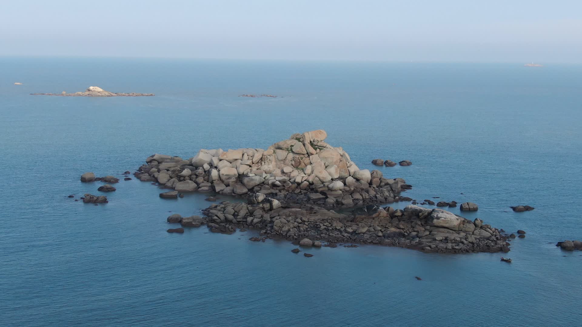 航拍蓝色海洋上礁石岛屿视频的预览图