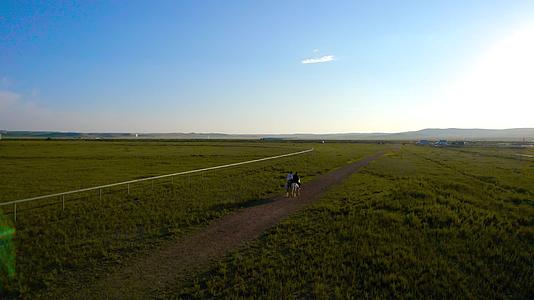 秋天的内蒙古锡林郭勒大草原及夕阳下骑马的游客视频的预览图