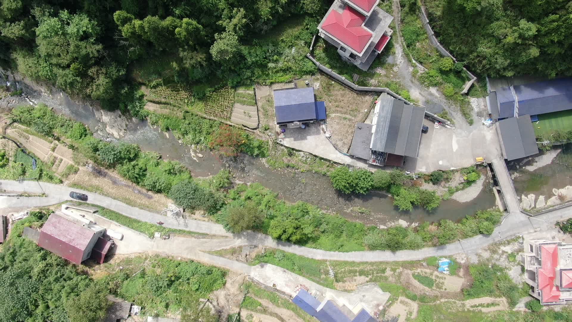 4K航拍山谷里小溪边的乡村民房视频的预览图