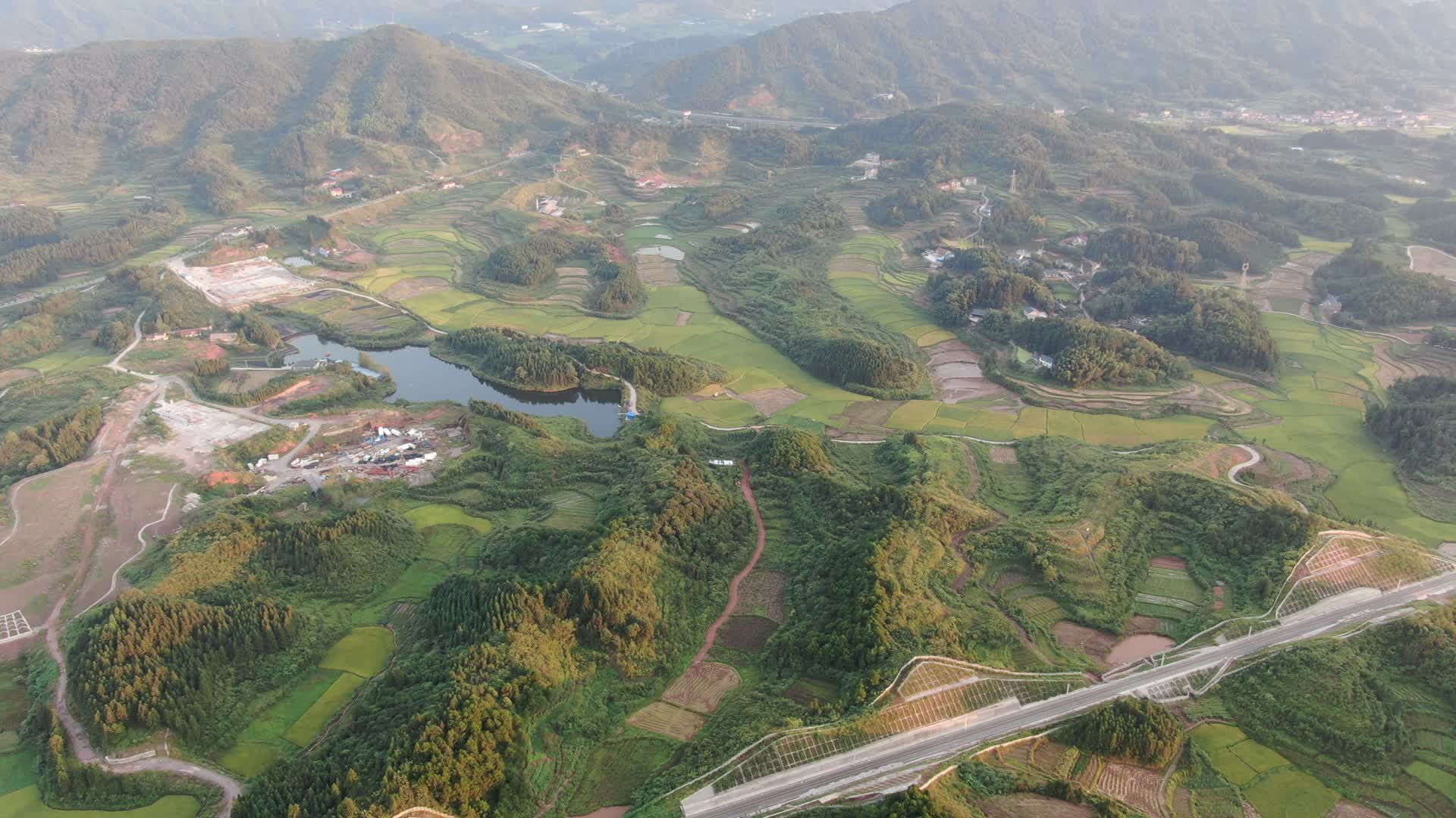 航拍丘陵山川中的稻田视频的预览图