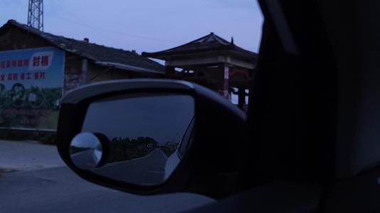 后视镜里傍晚行驶在乡间小道上的汽车视频的预览图