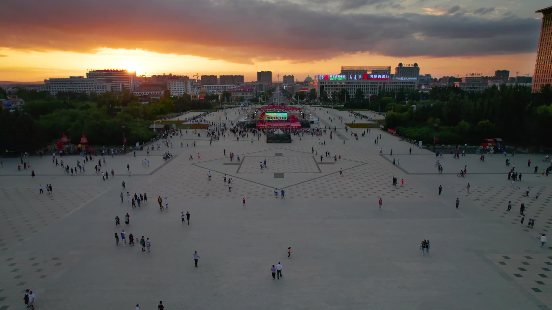 锡林浩特市晚霞中的人民广场及观看演出的人群傍晚5k航拍视频视频的预览图