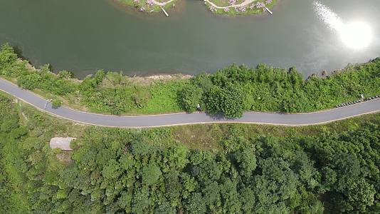 俯拍河边蜿蜒的公路航拍视频的预览图