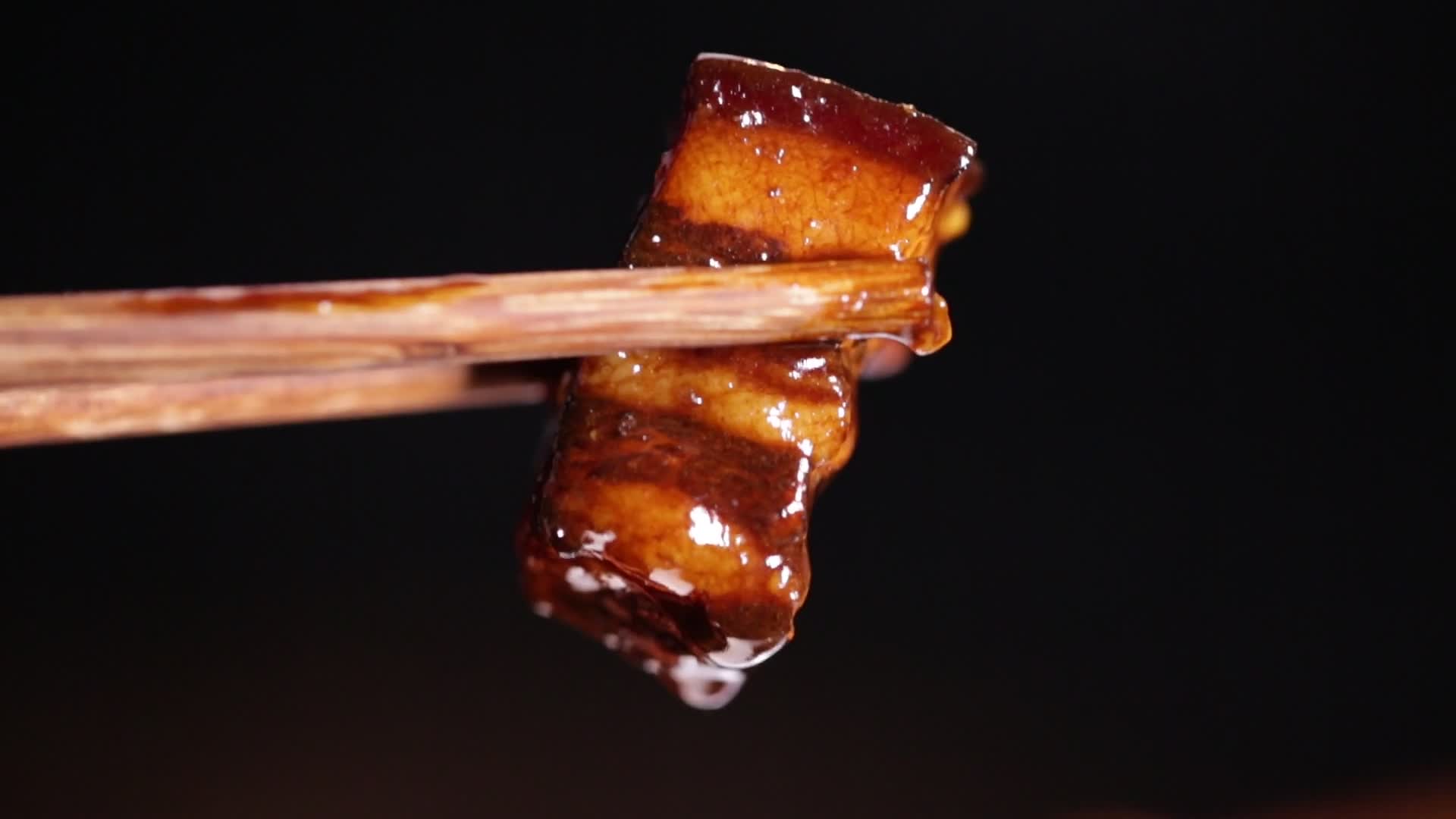 特写筷子夹起红烧肉视频的预览图