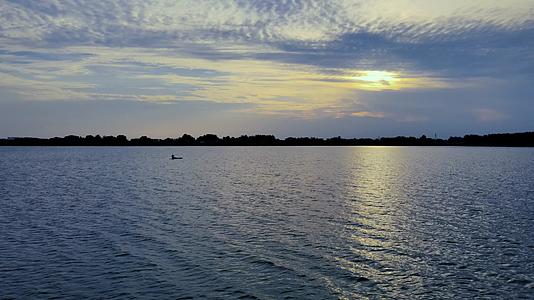 4K航拍夕阳下湖面上的皮划艇孤独的空镜头视频的预览图