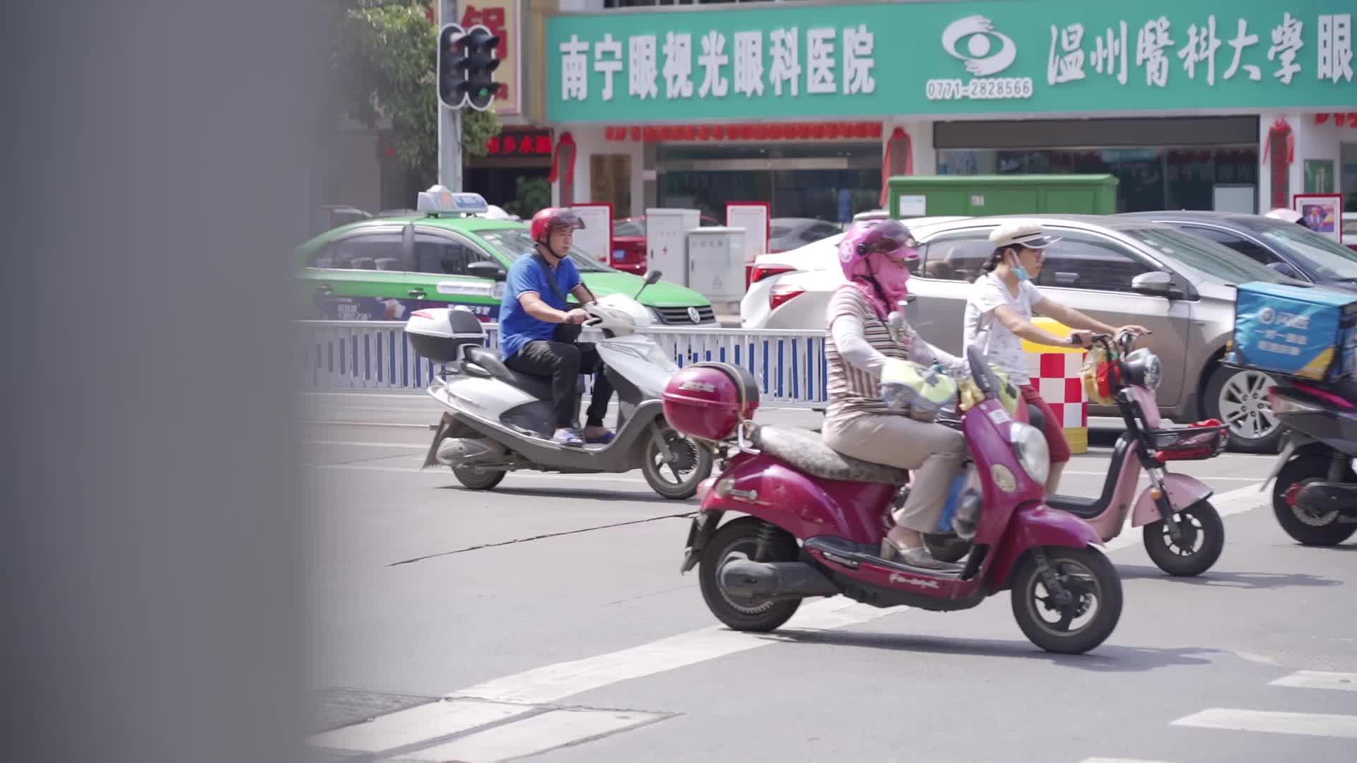 城市街道骑电瓶车的人视频的预览图