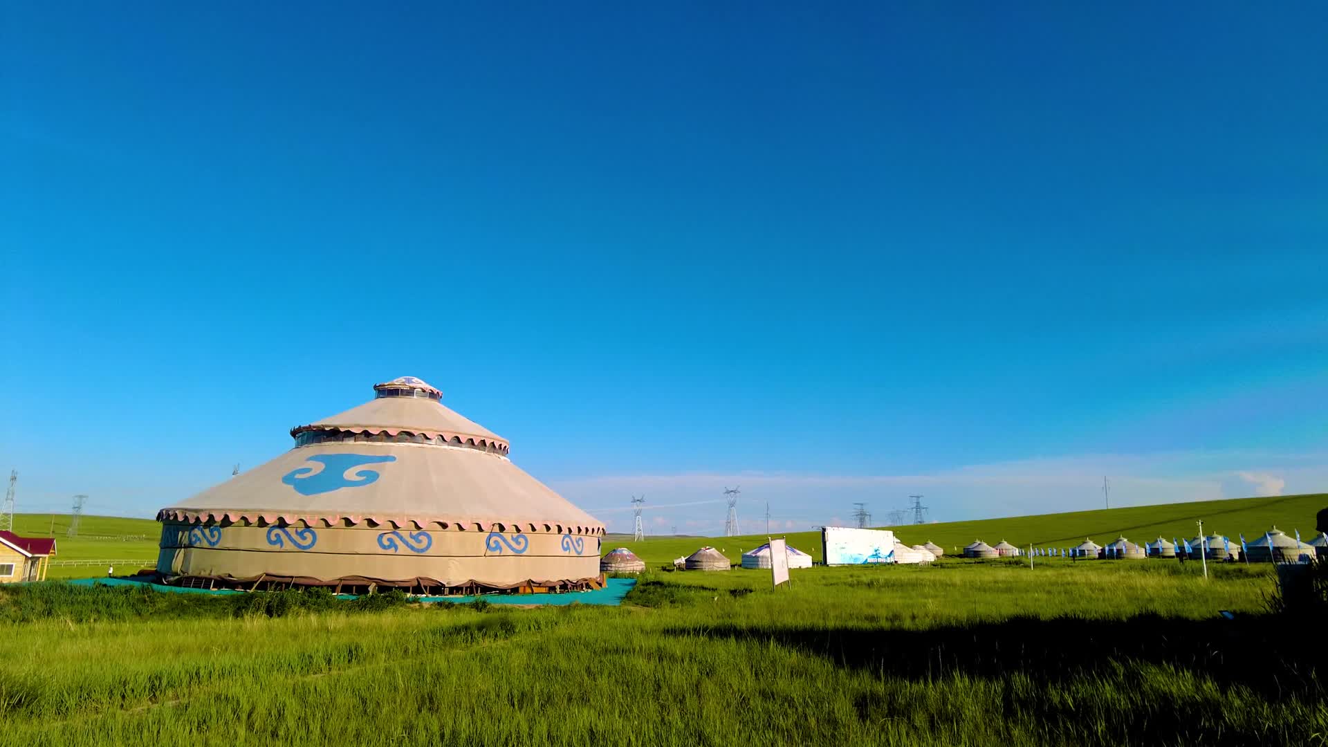 内蒙古蓝天下碧绿的草原上散落的蒙古包4k实拍视频视频的预览图