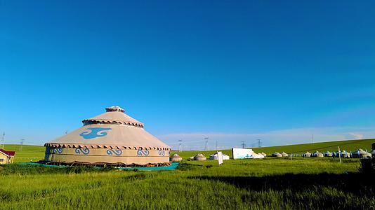 内蒙古蓝天下碧绿的草原上散落的蒙古包4k实拍视频视频的预览图