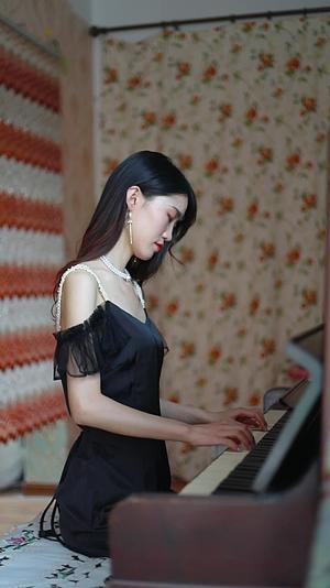 穿着黑色连衣裙的女孩在弹钢琴写真拍摄视频的预览图