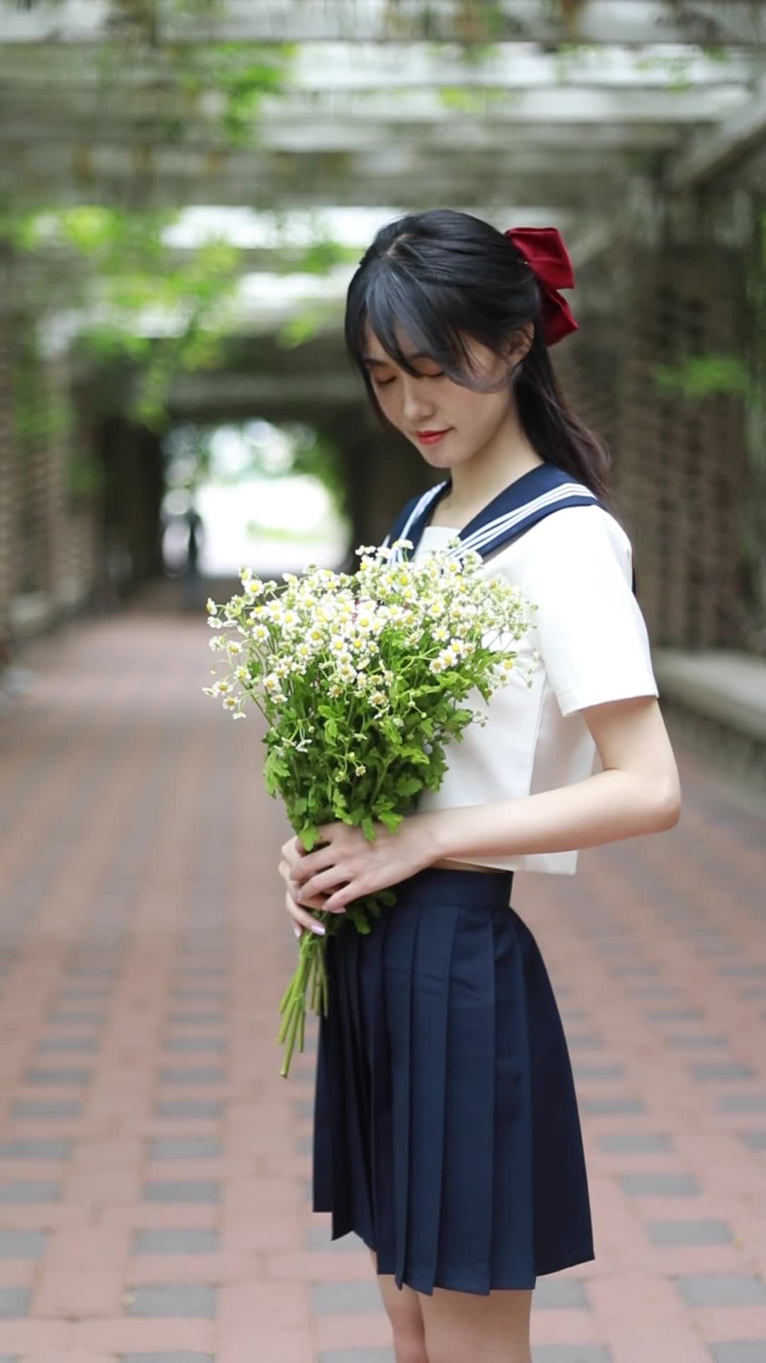 校园毕业季穿着JK服水手服的女孩拿着花朵视频的预览图