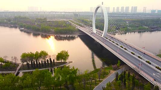 航拍郑州蝶湖公园戒指桥水中夕阳倒影视频的预览图