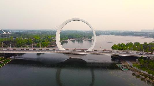 航拍从郑州蝶湖公园戒指桥中间穿越视频的预览图