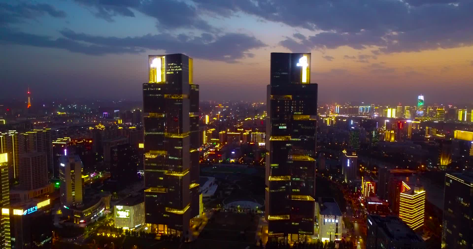 航拍环绕郑州双子塔夕阳夜景视频的预览图