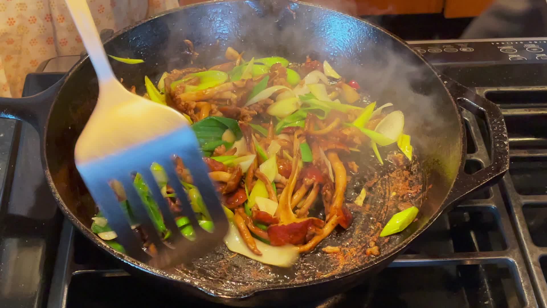 实拍家庭主妇用平板铸铁锅炒菜视频的预览图