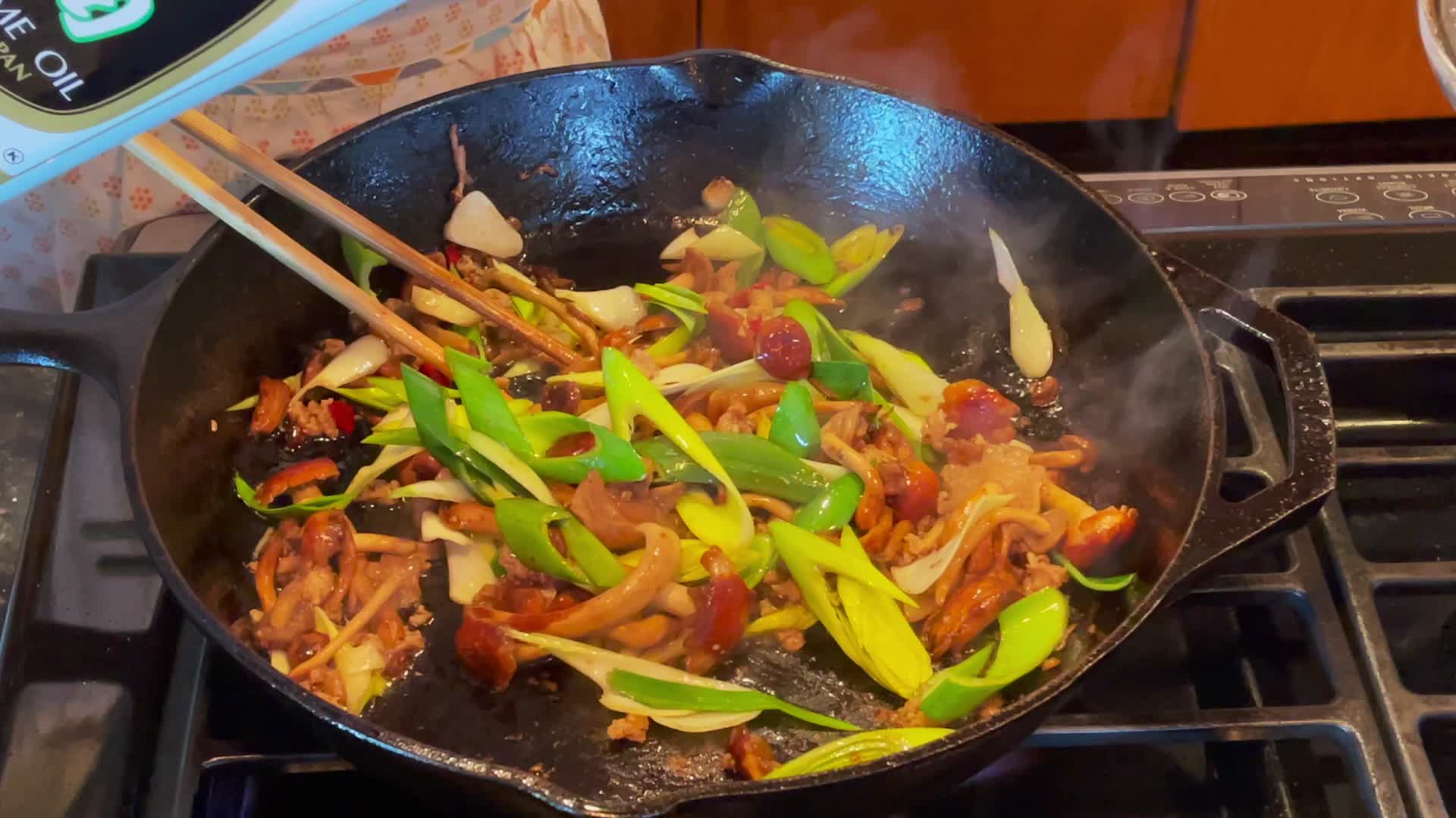 实拍家庭主妇用筷子和平板铸铁锅炒菜视频的预览图