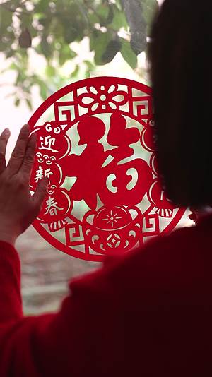 春节在家里贴窗花迎新年的中国女人视频的预览图