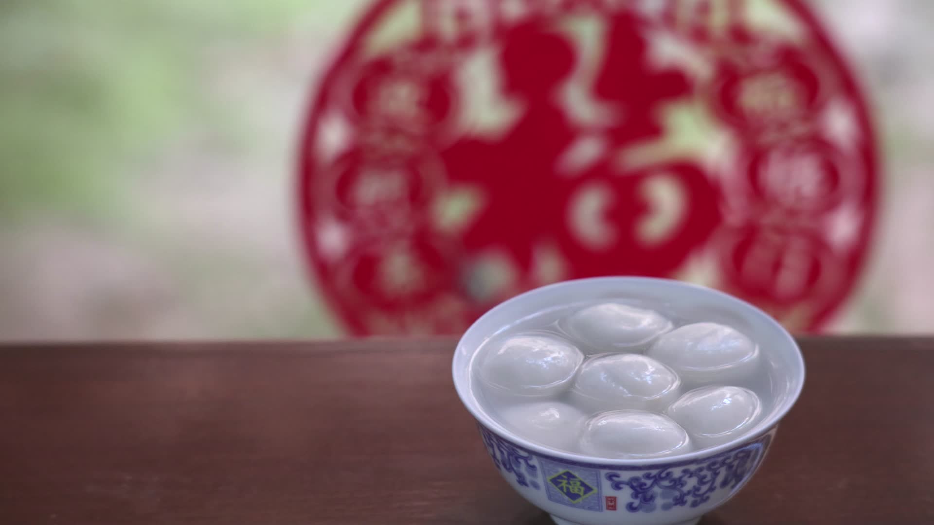 福字窗花背景的春节传统美食汤圆特写视频的预览图