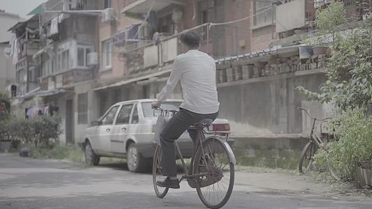 男子骑二八自行车穿梭在老街视频的预览图