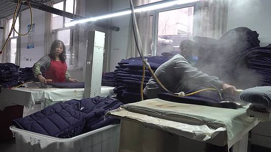 服装厂制衣厂女工熨烫衣服视频的预览图